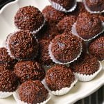 chocolate rum balls made with biscuit crumbs, butter, condensed milk, dark rum, and coated with chocolate sprinkles